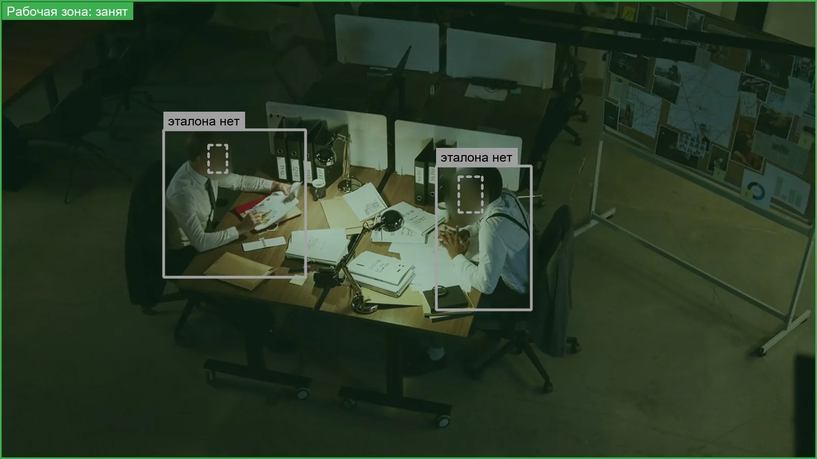 Dark office at night, ordinary overhead camera: both employees detected and tracked in low light; faces blurred